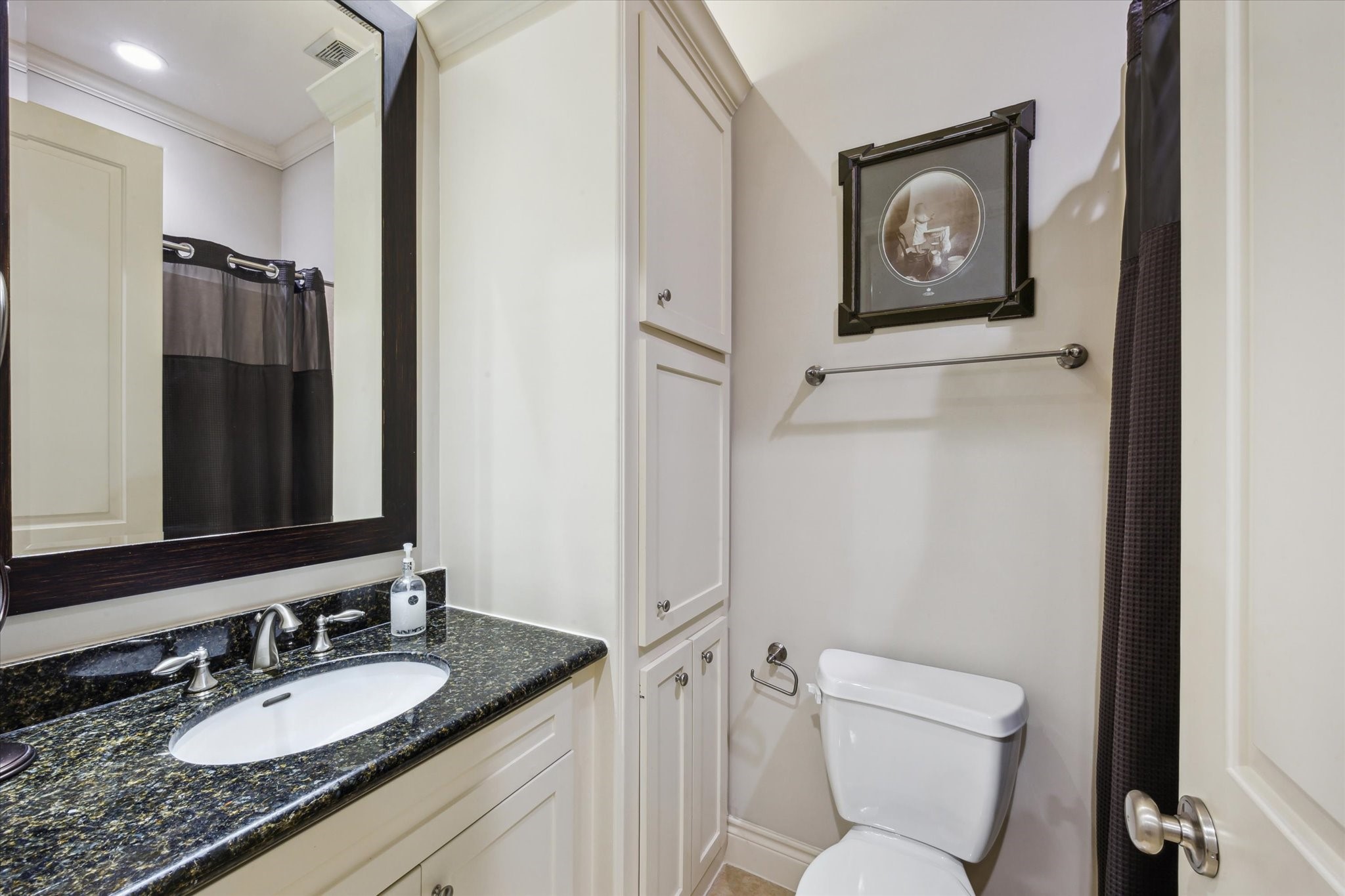 2405 Richton Street Houston, TX 77098 - Photo 20 of 24 a bathroom with a granite countertop toilet sink and mirror