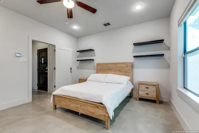 a bedroom with a bed and a ceiling fan