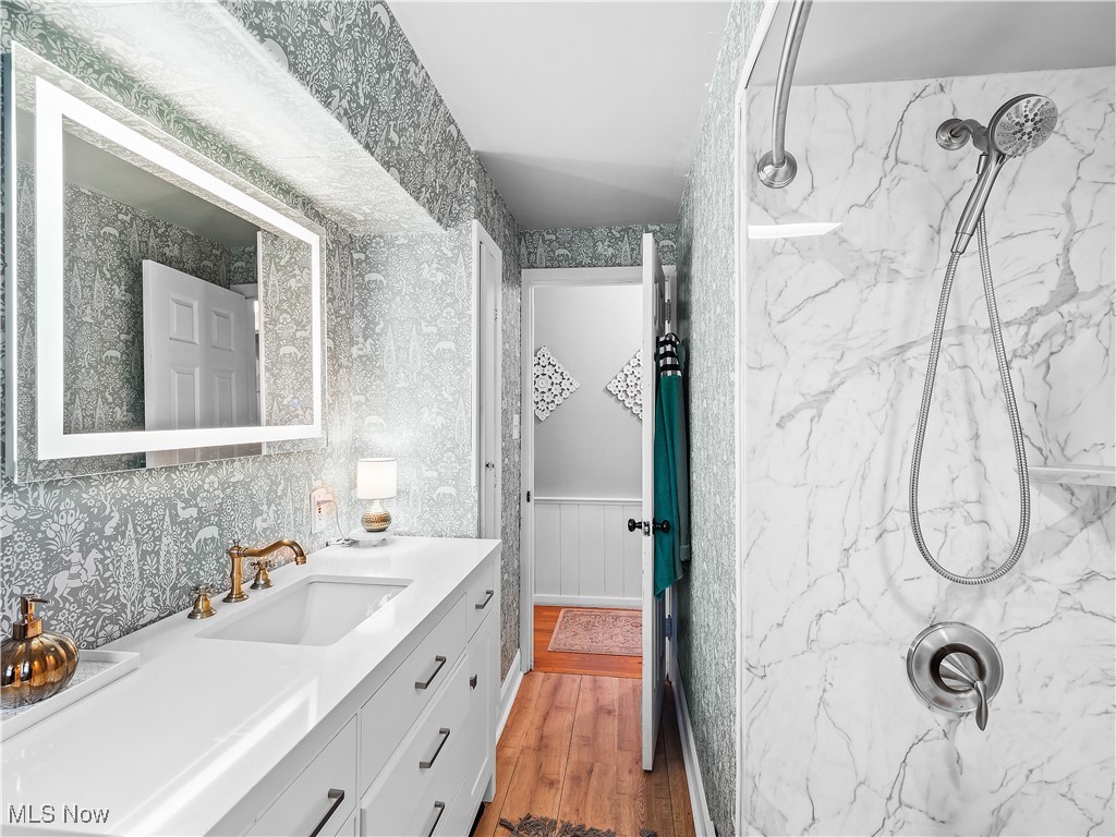 693 Avon Belden Road Avon Lake, OH 44012 - Photo 23 of 36 Bathroom featuring hardwood / wood-style flooring, vanity, and tiled shower