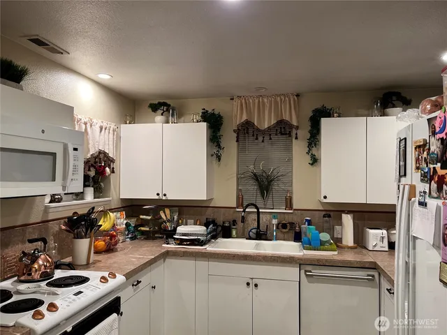 a kitchen with stainless steel appliances a sink a stove a refrigerator cabinets and a counter top space