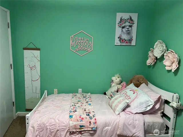 a bedroom with a bed and painting on the wall