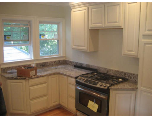 54 Beaconsfield Road, Unit 1 Brookline, MA 02445 - Photo 4 of 7 a kitchen with granite countertop a sink stove and cabinets