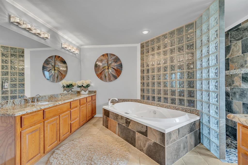50 Buckingham Lane Allen, TX 75002 - Photo 28 of 39 Full bath featuring a jetted tub, tile patterned flooring, vanity, and crown molding