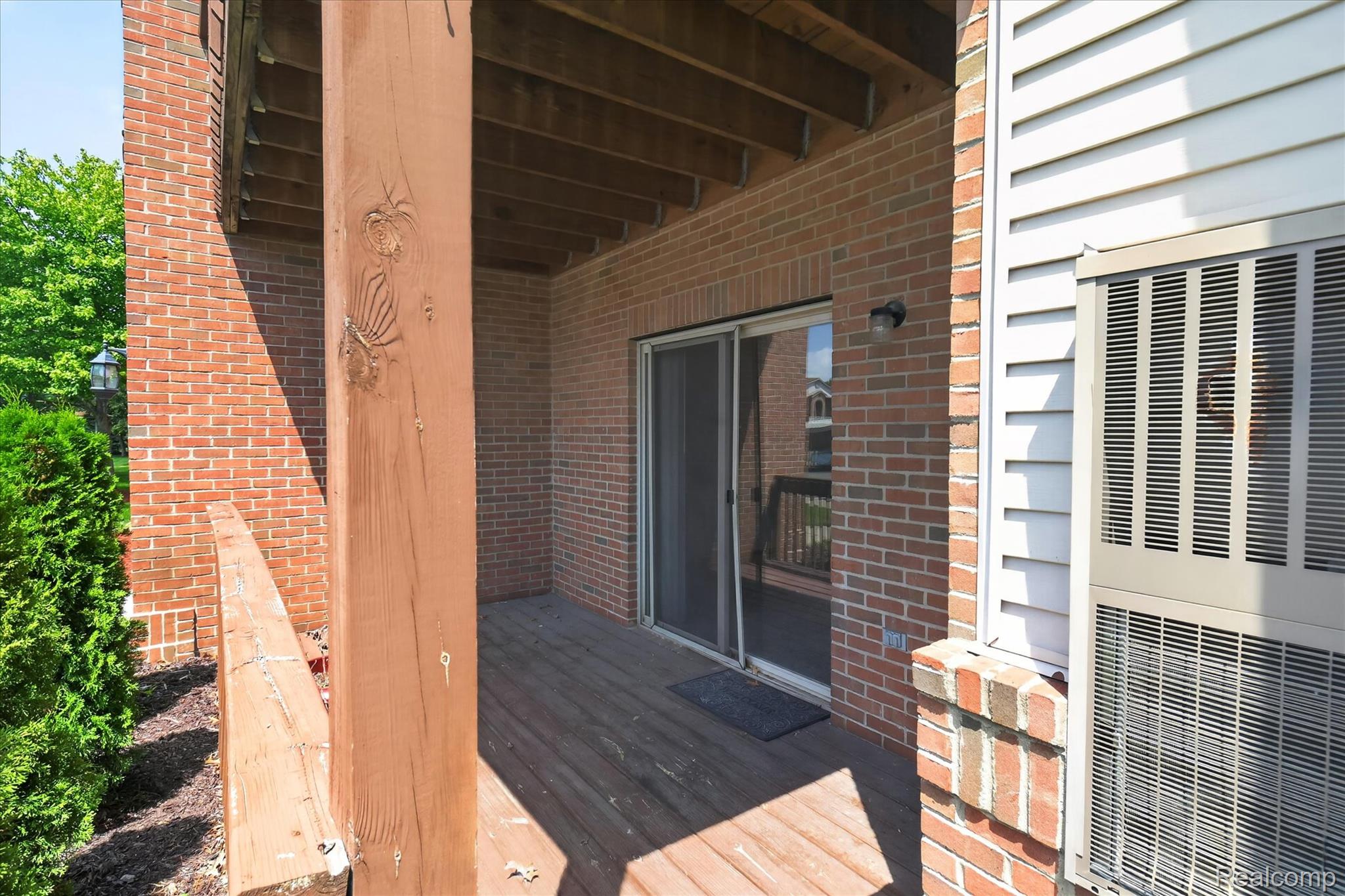45720 Prairiegrass Court Belleville, MI 48111 - Photo 30 of 31 Private outdoor patio featuring a wood-finish deck, brick exterior, and direct access through a sliding glass door