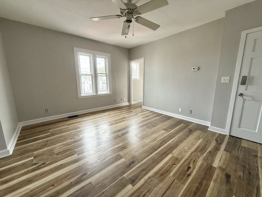 13 Brooks Avenue, Unit 2 Quincy, MA 02169 - Photo 3 of 15 a view of empty room with wooden floor and fan