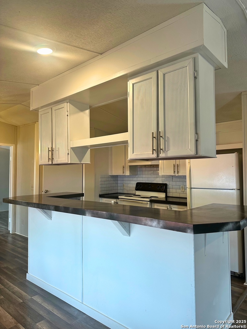 310 Duck Street Pleasanton, TX 78064 - Photo 3 of 6 a kitchen with stainless steel appliances granite countertop a sink and a stove