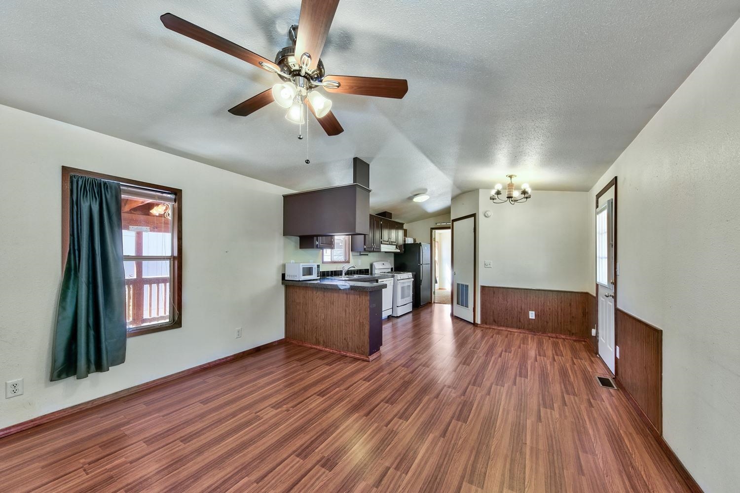 a view of a kitchen with a sink a ceiling fan and wooden floor