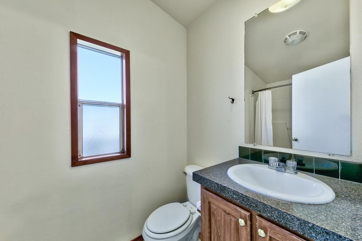 11070 Brockway Road, Unit 70 Truckee, CA 96161 - Photo 14 of 16 a bathroom with a granite countertop toilet a sink and a mirror