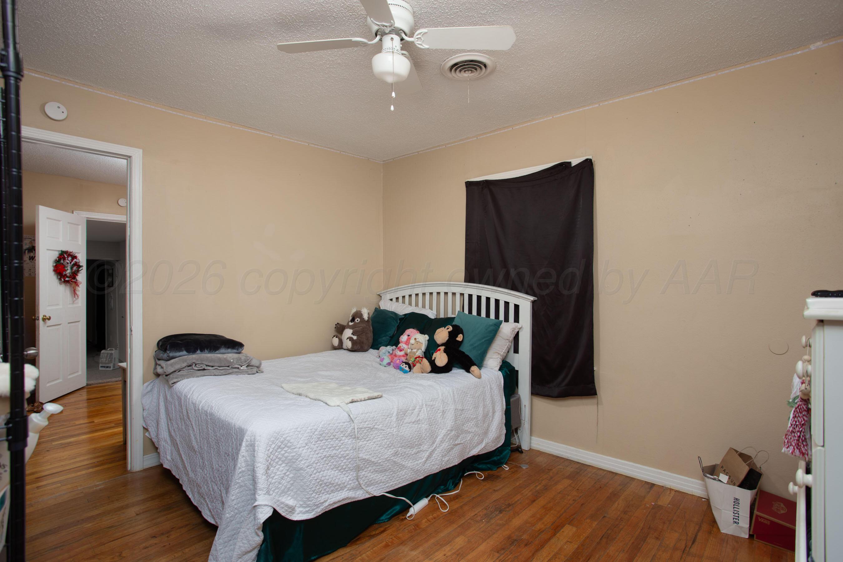 4003 South Van Buren Street Amarillo, TX 79110 - Photo 12 of 25 a bedroom with a bed and wooden floor