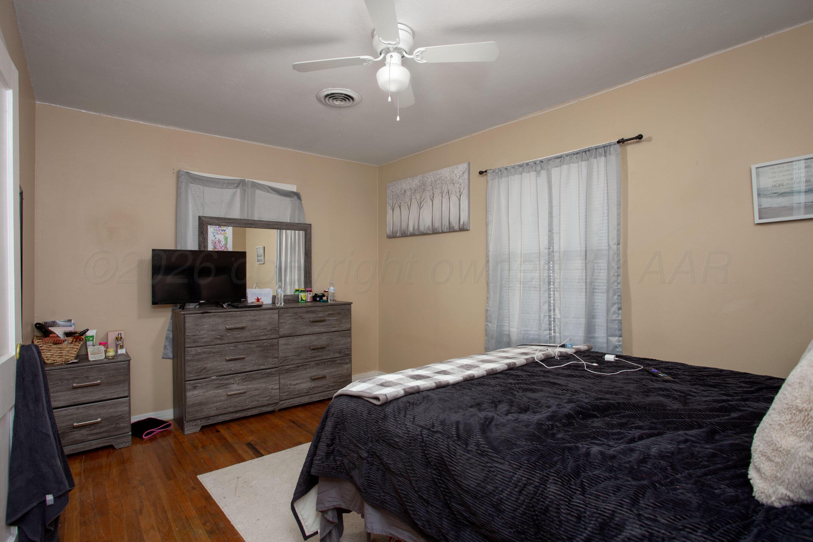 4003 South Van Buren Street Amarillo, TX 79110 - Photo 14 of 25 a bedroom with a bed and wooden floor