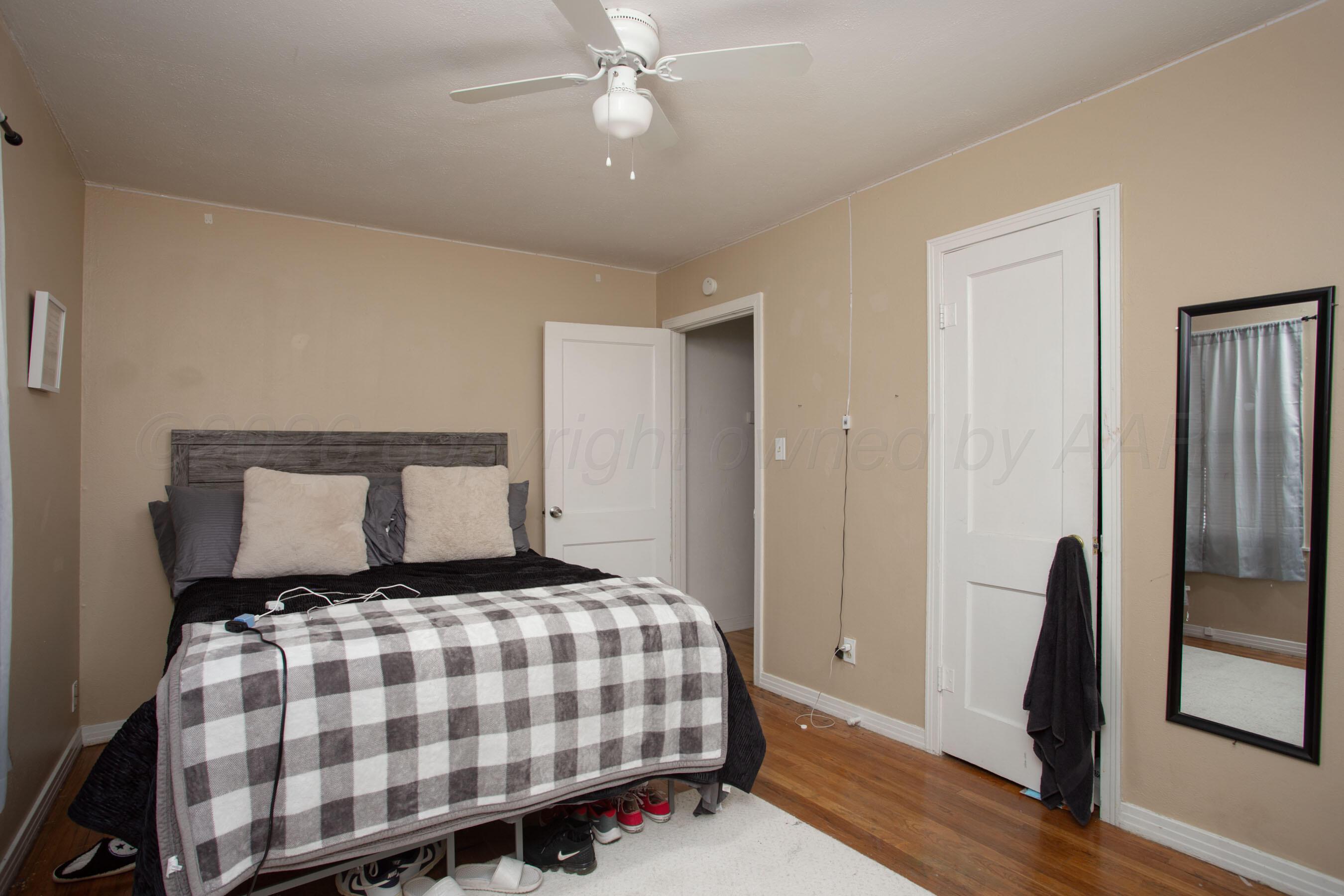 4003 South Van Buren Street Amarillo, TX 79110 - Photo 15 of 25 a bedroom with a bed and wooden floor