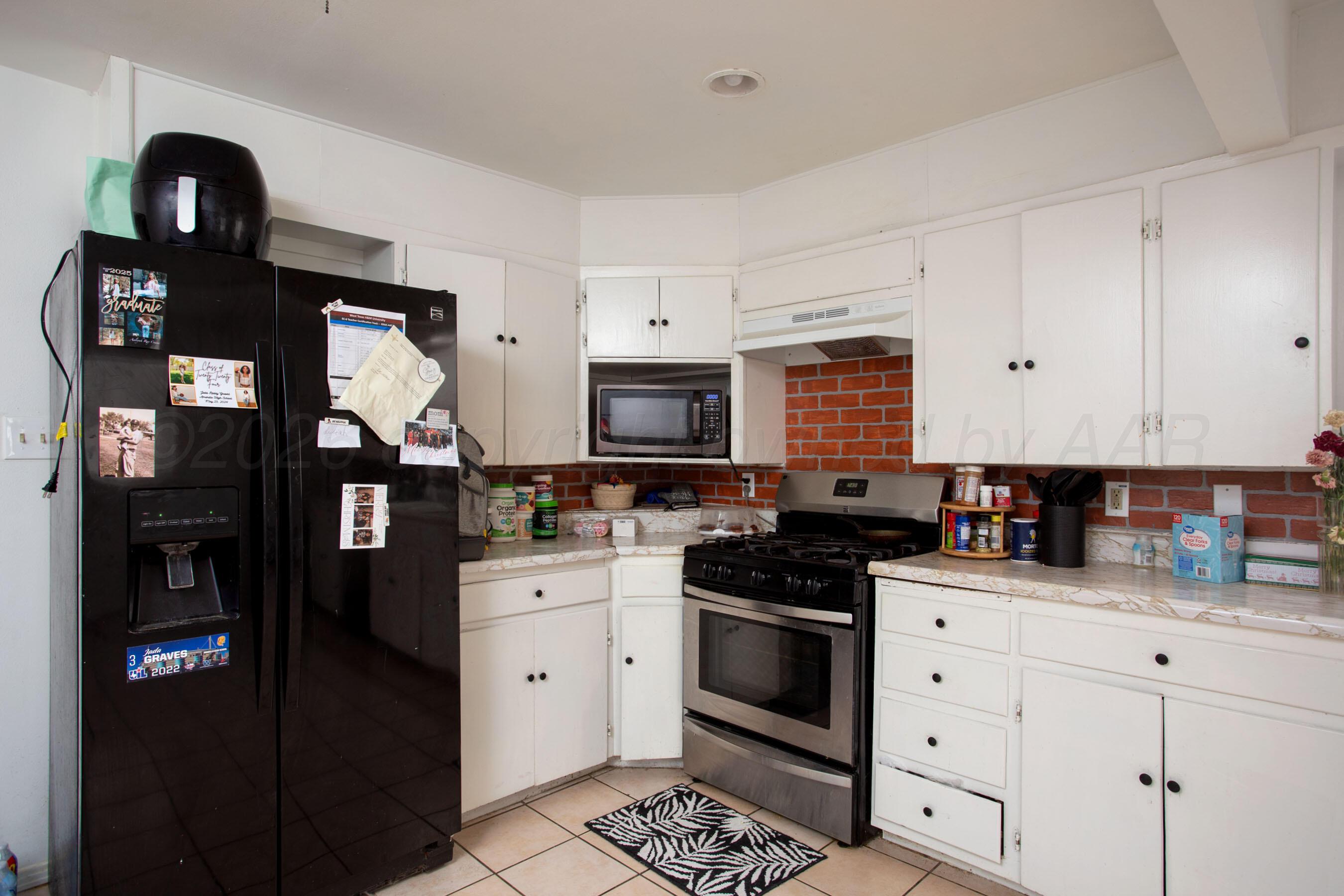 4003 South Van Buren Street Amarillo, TX 79110 - Photo 17 of 25 a kitchen with stainless steel appliances a stove cabinets and a refrigerator