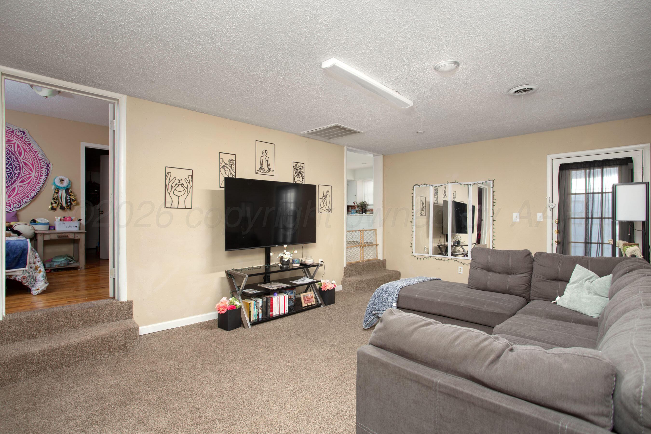4003 South Van Buren Street Amarillo, TX 79110 - Photo 2 of 25 a living room with furniture and a flat screen tv