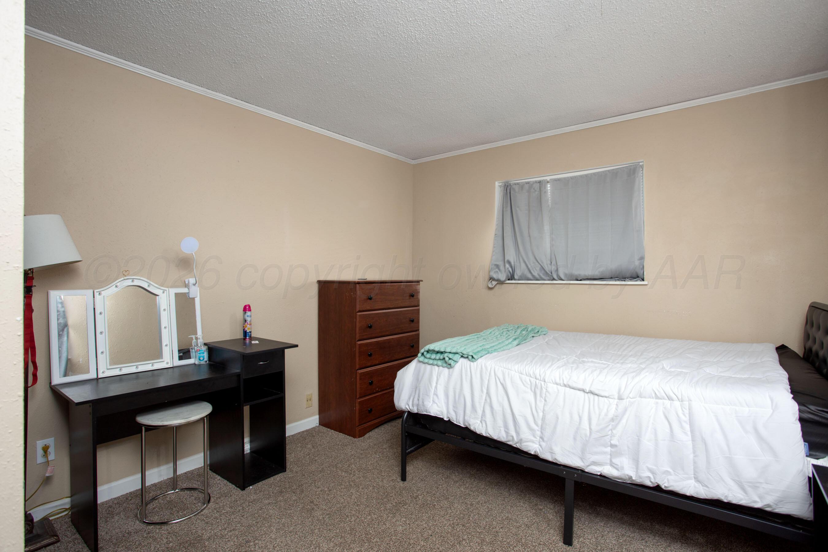 4003 South Van Buren Street Amarillo, TX 79110 - Photo 6 of 25 a bedroom with a bed and a table in it