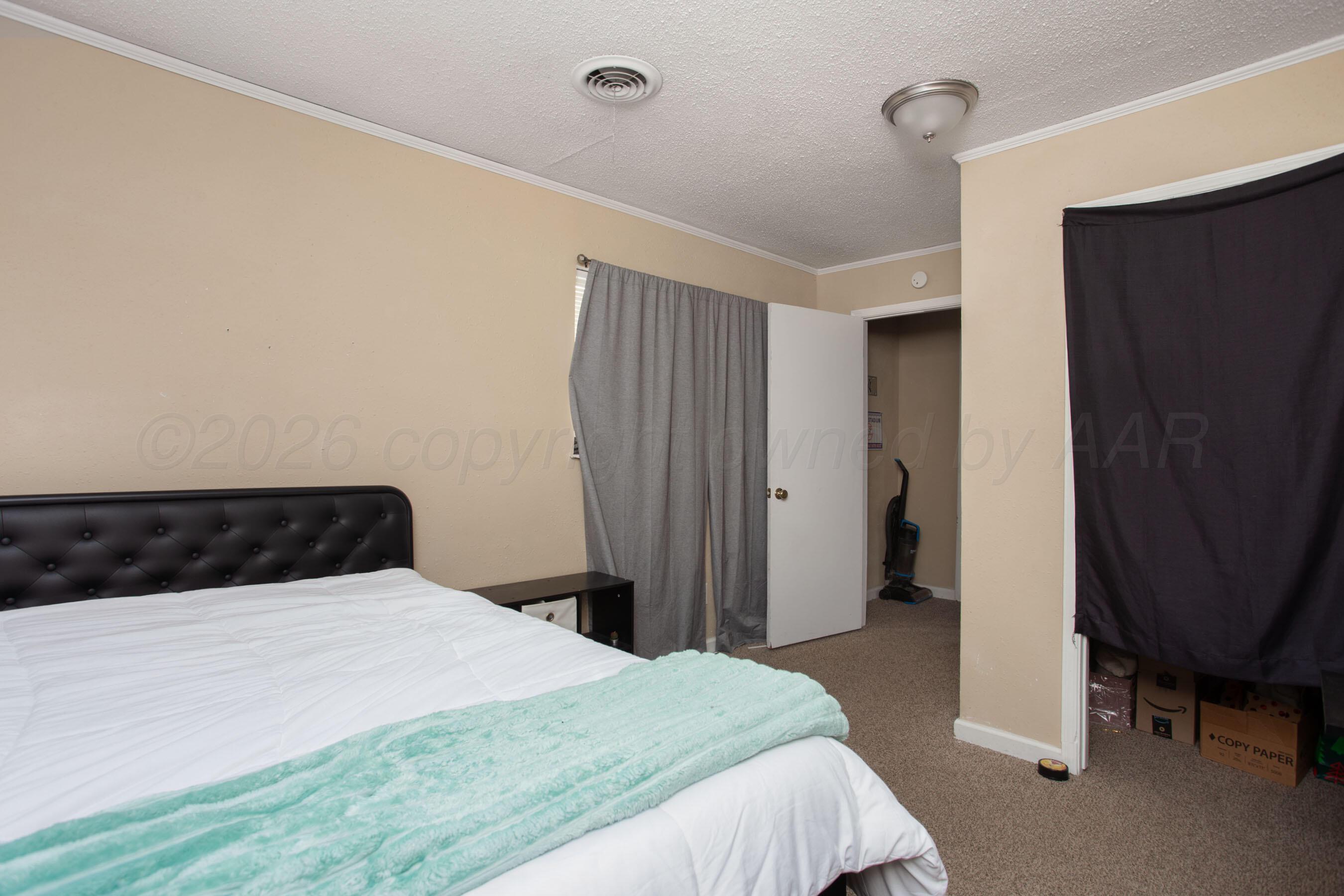 4003 South Van Buren Street Amarillo, TX 79110 - Photo 7 of 25 a bedroom with a bed and a chair in it