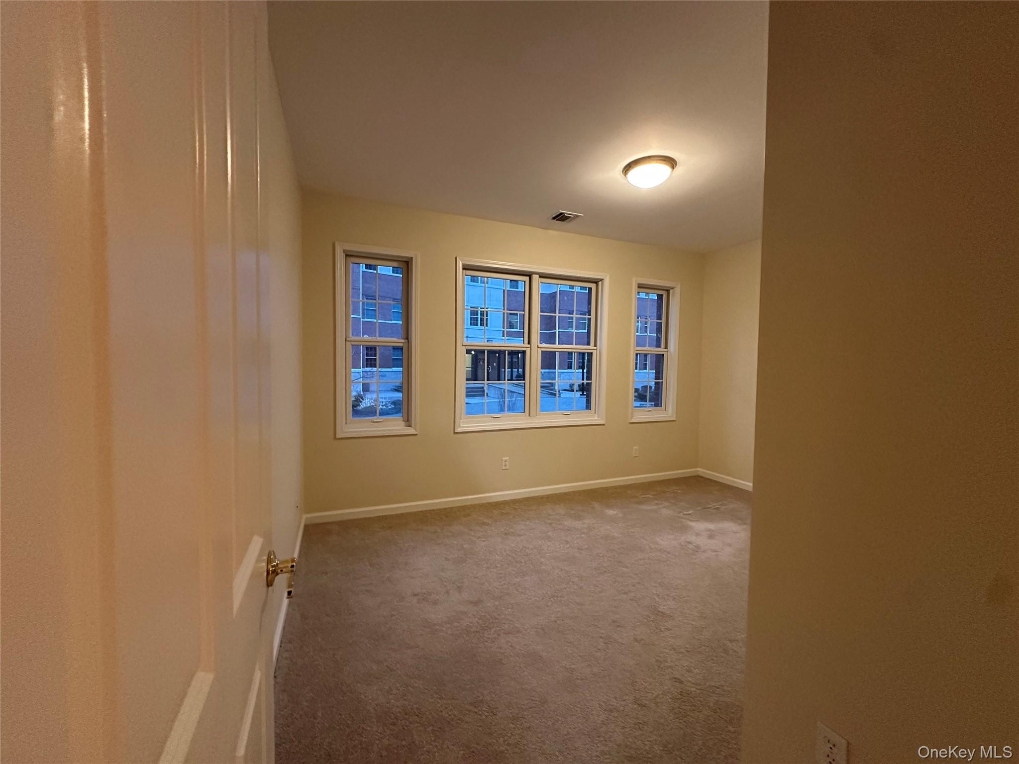 75 Quaker Avenue, Unit 117 Cornwall, NY 12518 - Photo 14 of 21 an empty room with large window and entryway