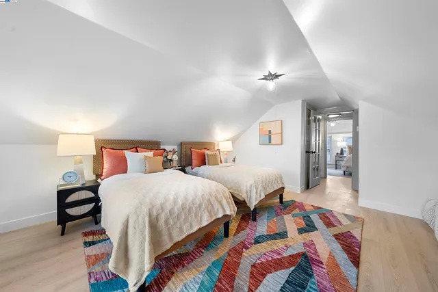 a bedroom with two beds and painting on the wall