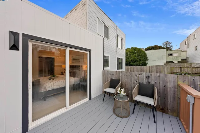 a balcony with chairs and wooden floor