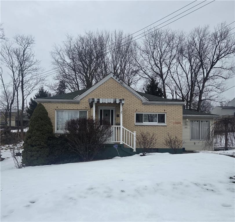 a front view of a house with a yard covered in snow