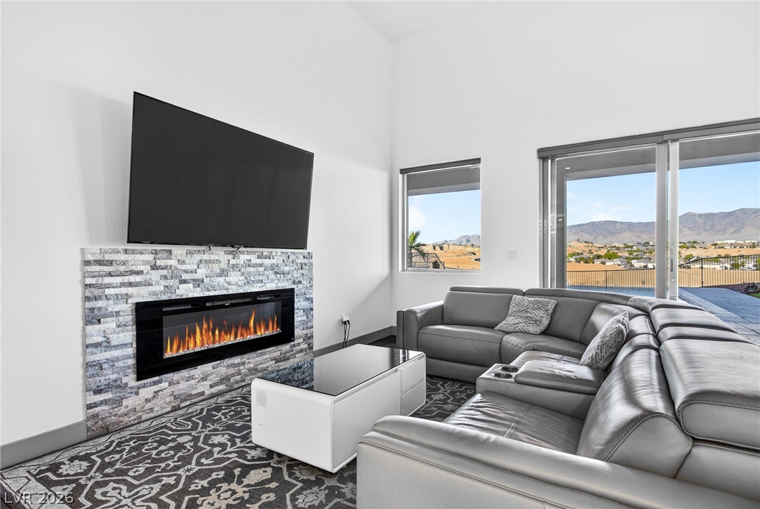 1460 Blue Ridge Trail Mesquite, NV 89027 - Photo 5 of 39 A spacious great room features a modern fireplace and sliding glass doors that open to captivating mountain views.