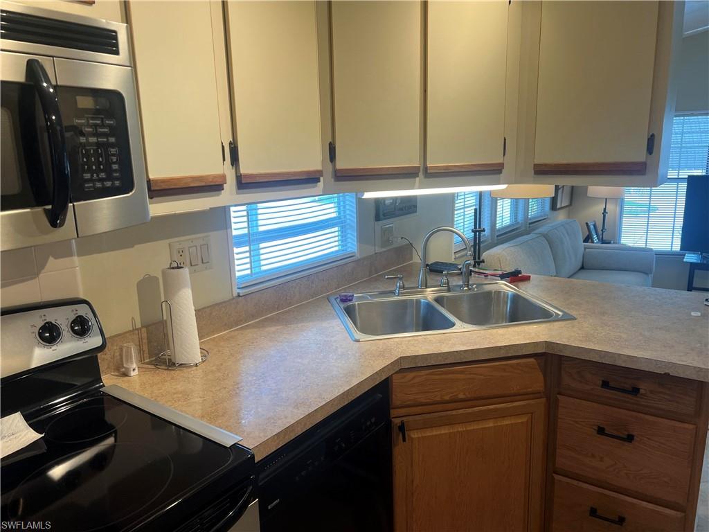 159 Cheetah Drive, Unit 159 Naples, FL 34114 - Photo 22 of 31 a kitchen with stainless steel appliances granite countertop a sink stove and cabinets