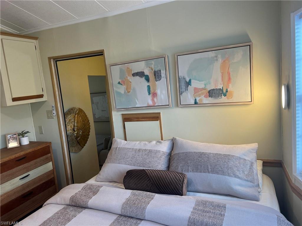 159 Cheetah Drive, Unit 159 Naples, FL 34114 - Photo 26 of 31 a bedroom with a large bed and a painting on the wall
