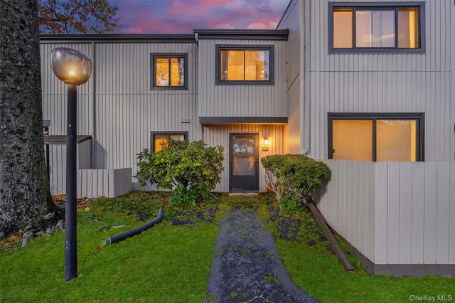 a view of a house with brick walls and a small yard