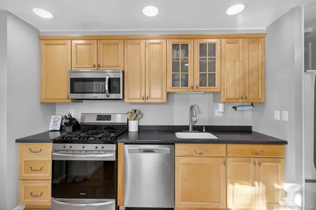 a kitchen with stainless steel appliances granite countertop white cabinets stove a sink and dishwasher