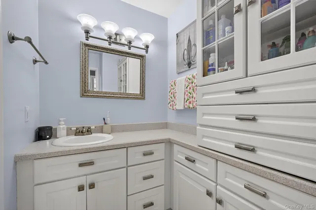 a bathroom with a sink mirror and vanity