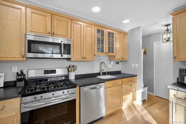 a kitchen with stainless steel appliances granite countertop a stove a microwave and a refrigerator