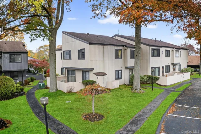 a front view of a house with garden and trees