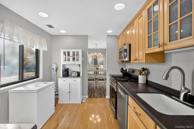 a kitchen with stainless steel appliances granite countertop a sink stove refrigerator and cabinets