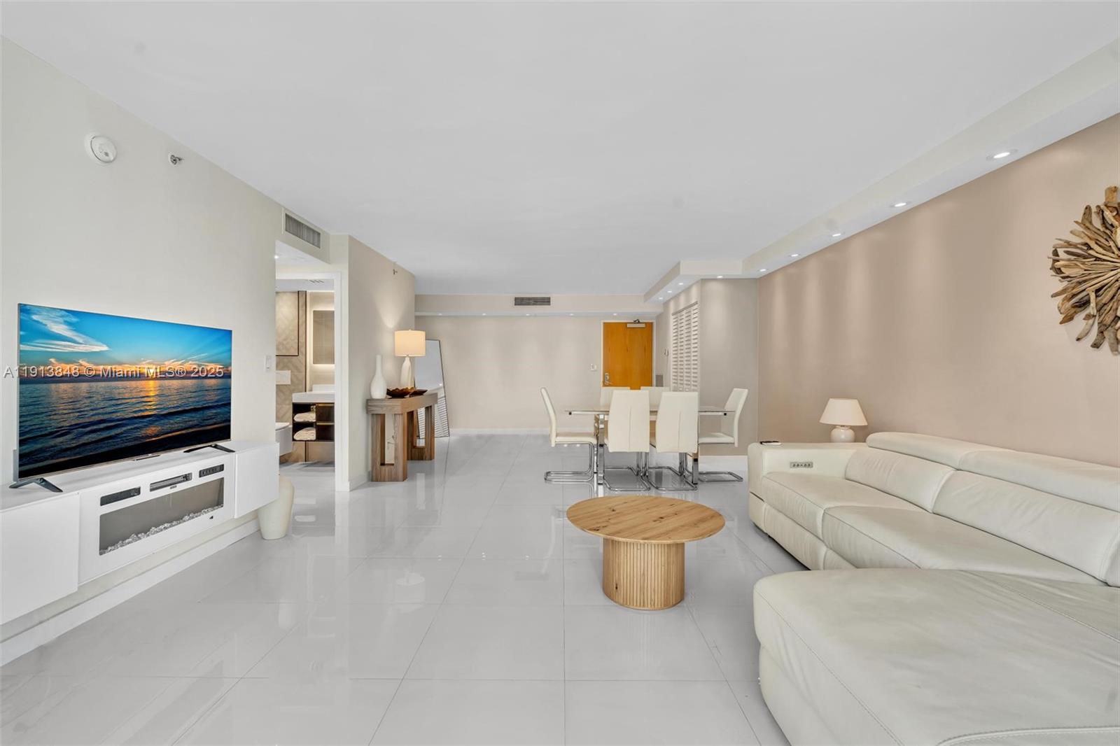 9195 Collins Avenue, Unit 303 Surfside, FL 33154 - Photo 24 of 44 a living room with furniture and a flat screen tv