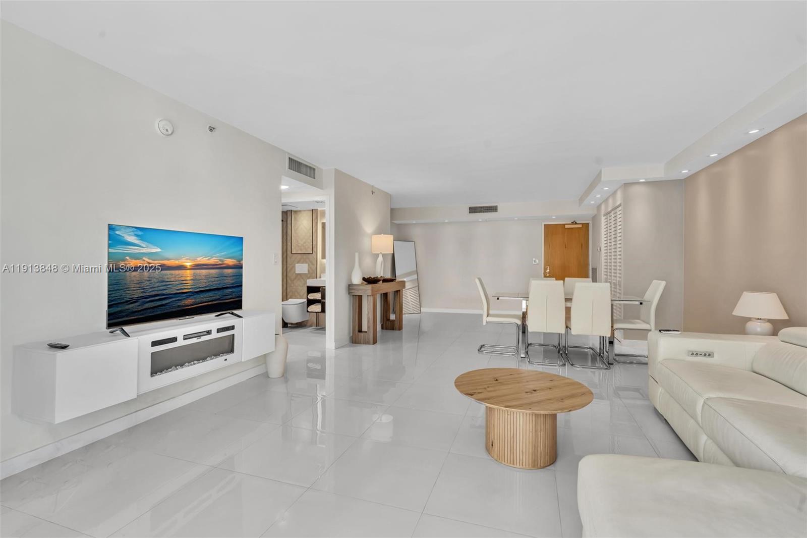 9195 Collins Avenue, Unit 303 Surfside, FL 33154 - Photo 25 of 44 a living room with furniture and a flat screen tv