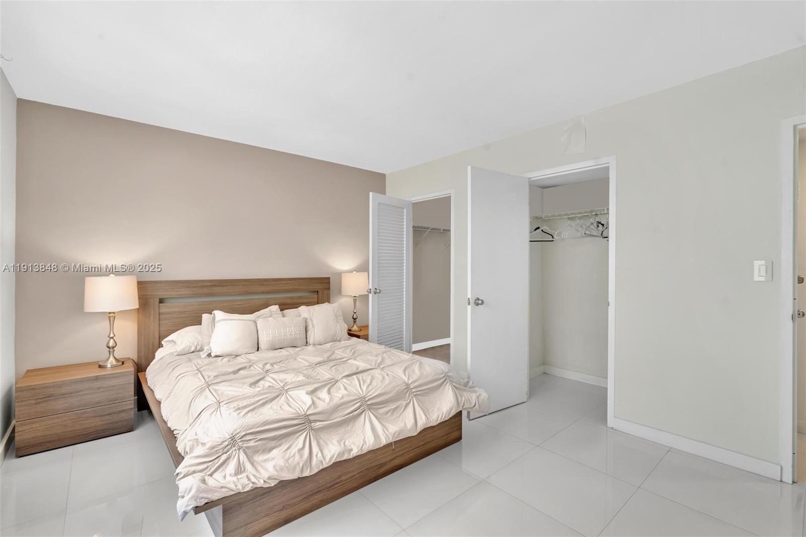 9195 Collins Avenue, Unit 303 Surfside, FL 33154 - Photo 32 of 44 a bedroom with a bed and a night lamp