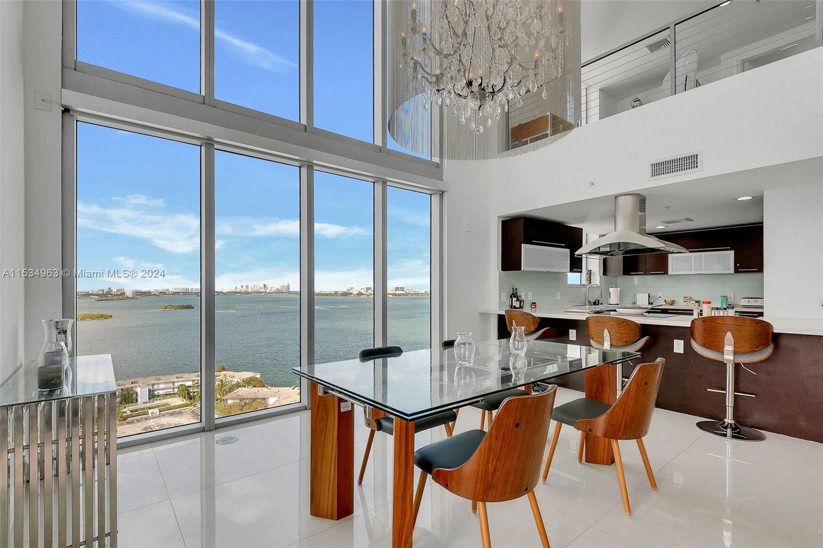 a room with stainless steel appliances kitchen island granite countertop dining table chairs and a view of living room