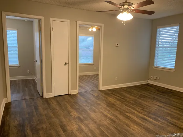 an empty room with wooden floor and closet area