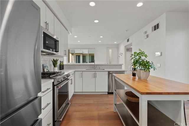 a kitchen with stainless steel appliances granite countertop a sink a stove and a refrigerator