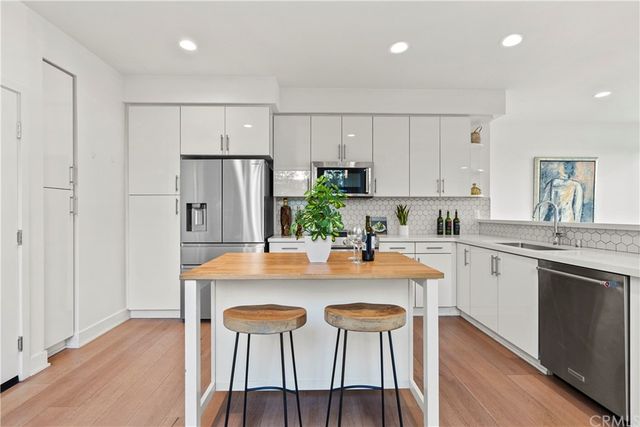 a kitchen with kitchen island granite countertop a white cabinets and refrigerator