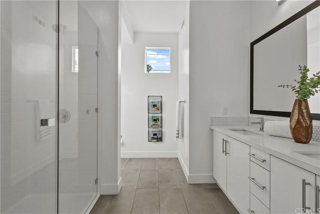a bathroom with a granite countertop sink two mirror and window