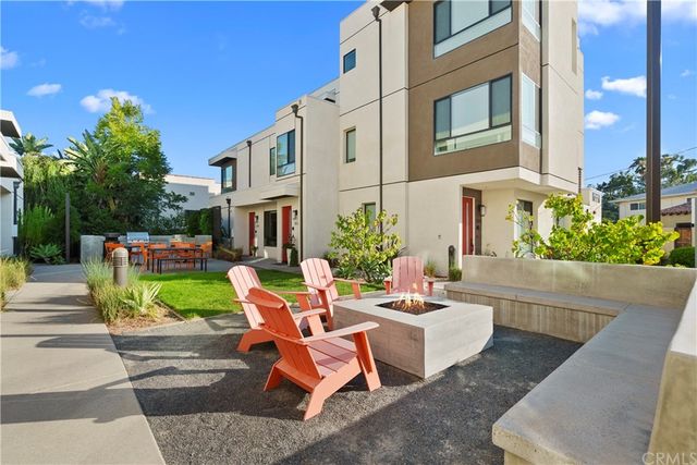 a view of a patio with couches table and chairs and potted plants
