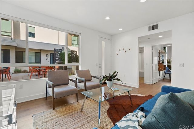 a living room with furniture wooden floor and a large window