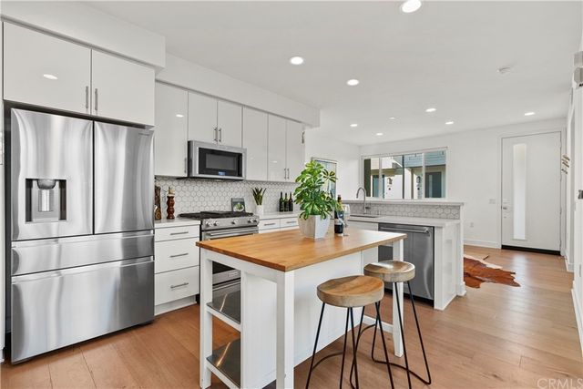 a kitchen with stainless steel appliances granite countertop a refrigerator and a stove top oven