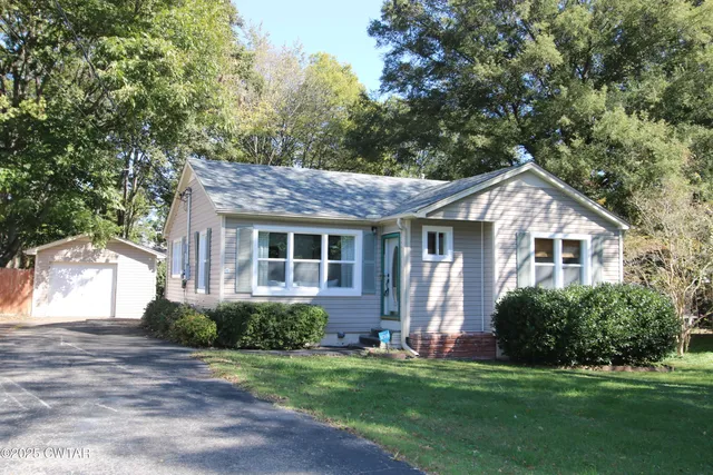 a front view of a house with a yard and green space