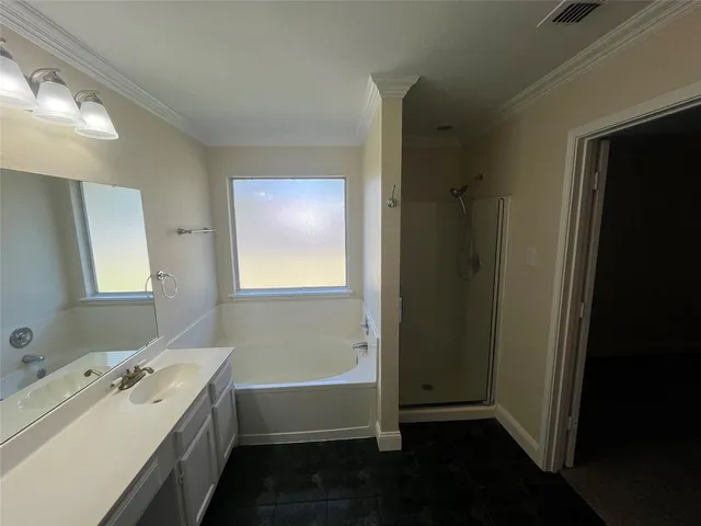 a bathroom with a double vanity sink and mirror with bathtub