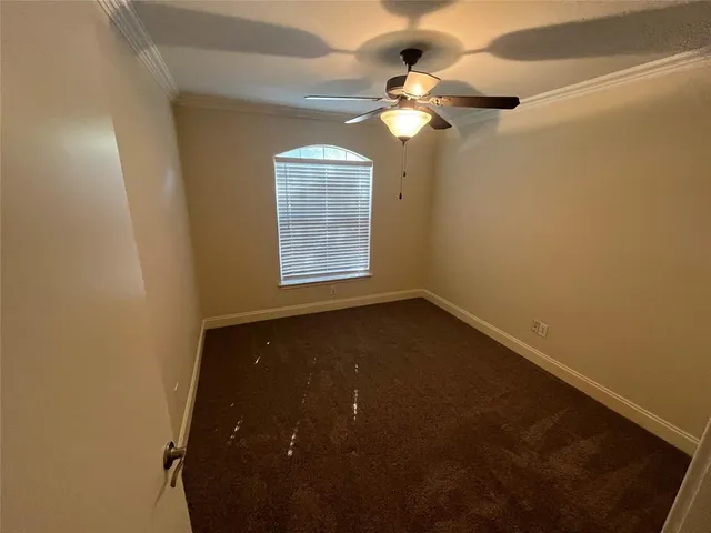 an empty room with a chandelier fan and a window