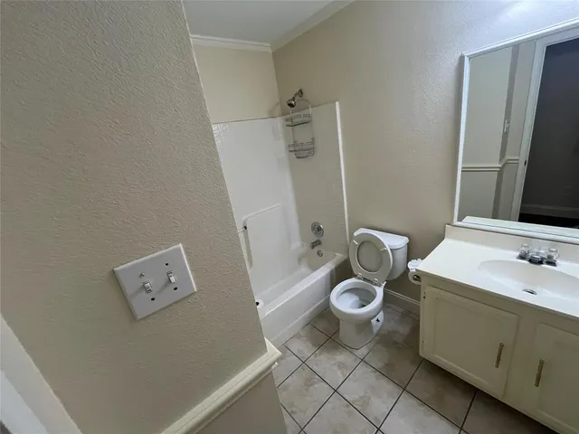a bathroom with a granite countertop toilet and a sink