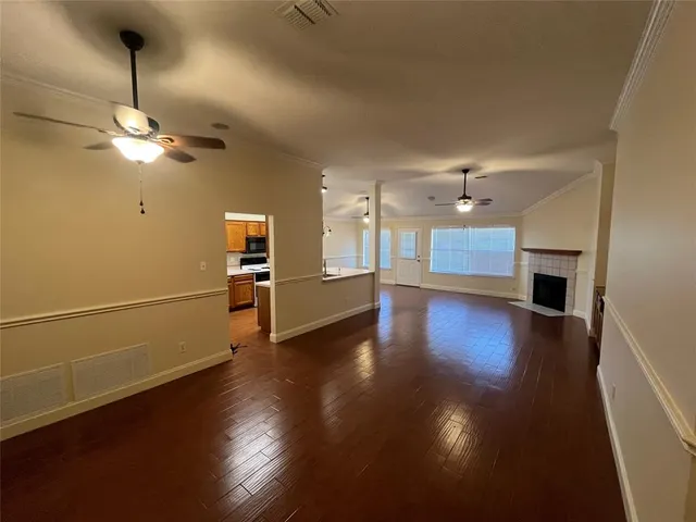 a view of a room with wooden floor and kitchen view