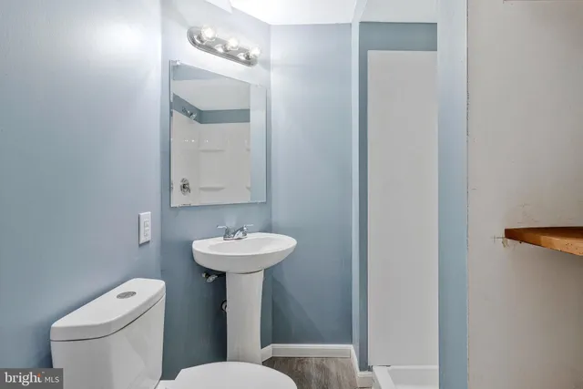 a bathroom with a toilet sink and mirror