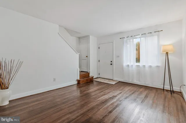 an empty room with wooden floor and a window